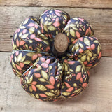 Handmade cotton pumpkin - brown background with autumn leaves