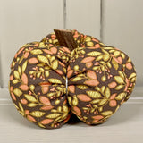 Handmade cotton pumpkin - brown background with autumn leaves